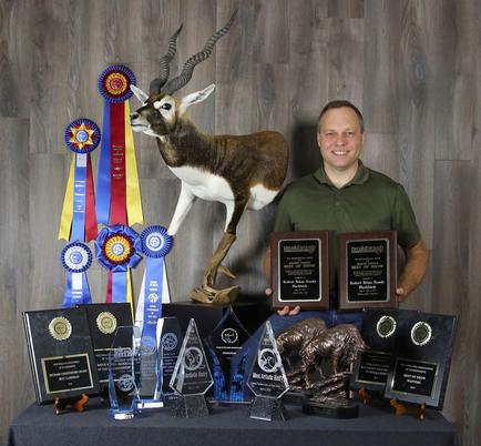 Brain standing with his mount and awards